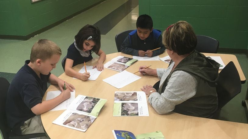 Kiser School second-graders work on a writing assignment with a classroom aide last school year. Dayton schools and others that serve many low-income, high-need students have a chance at sharing $35 million in grant money that Ohio will receive. JEREMY P. KELLEY / STAFF