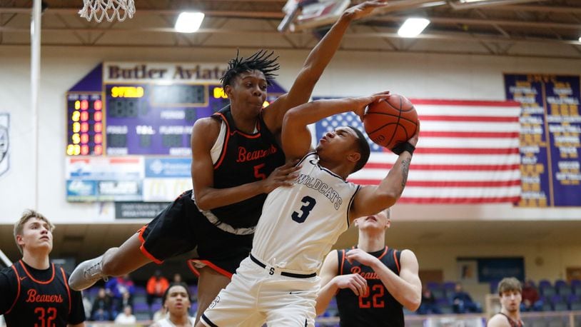 Beavercreek’s Siloam Baldwin leaps to block a shot by Springfield’s Jeff Tolliver during their Division I district semifinal game on Friday night at the Vandalia Butler Student Activity Center. The Beavers won 64-44. CONTRIBUTED PHOTO BY MICHAEL COOPER