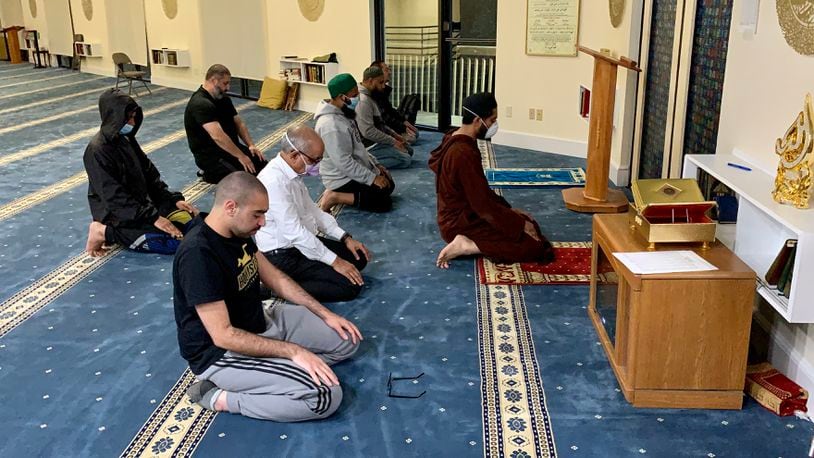 Men at Dayton Mercy Society Mosque in Miamisburg participate in evening prayer. Muslims pray five times each day. Dr. Abdul Wase (white shirt) said that if more Americans were to visit mosques and get to know Muslims, they would realize it is a peaceful religion.