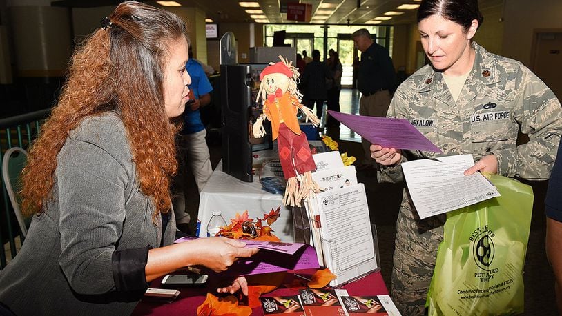 Maj. Allison Barkalow, Air Force Materiel Command deputy branch chief, views information displayed at a charity table during the Miami Valley Combined Federal Campaign kick-off event at Wright State University’s Nutter Center, Oct. 11. CFC provides an opportunity to learn about the work charitable organizations do locally, statewide, regionally, nationally and internationally. (U.S. Air Force photo/Michelle Gigante)
