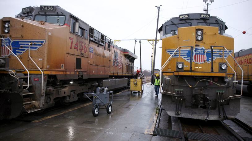 FILE - A Union Pacific worker walks between two locomotives that are being serviced in a railyard in Council Bluffs, Iowa, on Dec. 15, 2023. Union Pacific reports earnings on Thursday, April 25, 2024. (AP Photo/Josh Funk)