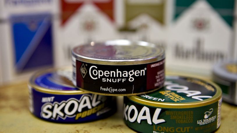 Cans of Skoal and Copenhagen brand smokeless tobacco sit on display in front of Marlboro and Parliament brand cigarettes in a deli in New York, U.S., on Thursday, Jan. 28, 2010. Altria Group Inc., the largest U.S. tobacco company, said fourth-quarter profit rose 6.8 percent, bolstered by the acquisition of snuff maker UST Inc. Photographer: Daniel Acker/Bloomberg via Getty Images