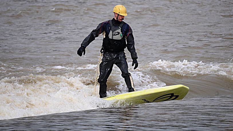 Chris Romie, enjoys river surfing on the Great Miami River near downtown Dayton on Friday, March 24, 2017. Making the Great Miami Riverway a top place to visit in Ohio was a topic of discussion at the 10th Annual River Summit at the University of Dayton on Friday. Staff Photo/Marshall Gorby