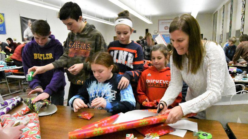 Megan Reinhart, right, helps young people, including students from Morton Middle School in Vandalia, wrap during the Project Believe Wrap Party in Tipp City. CONTRIBUTED.
