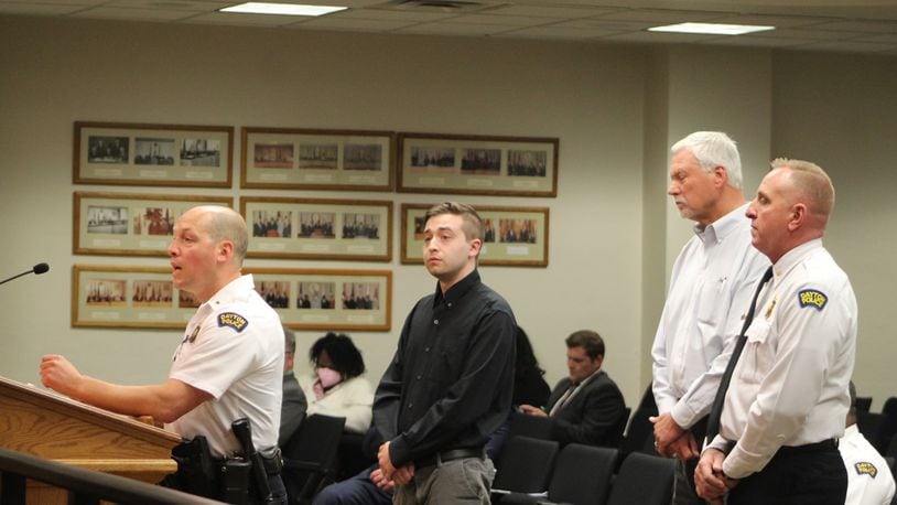 Zach Curry (in black shirt) and Butch Brown (second from right) will host a new podcast focused on unsolved homicide and sexual assault cases in Dayton, with a goal of generating tips and leads. They will receive assistance from the Dayton Police Department's Cold Case Unit. Dayton police Lt. Steve Bauer (speaking to City Commission) and Major Brian Johns (right) discussed the new podcast. CORNELIUS FROLIK / STAFF