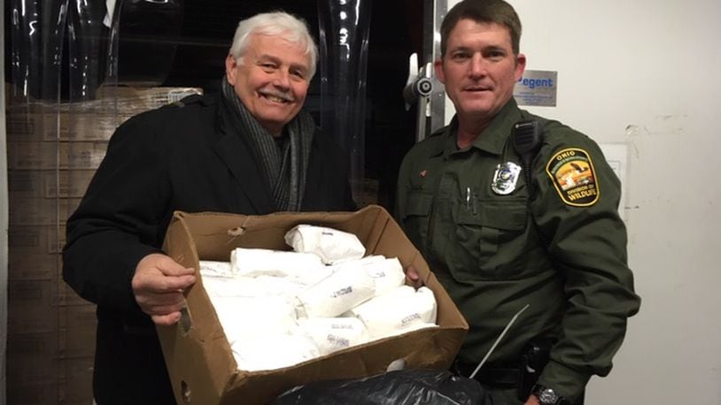 State Wildlife Officer Timothy Rourke and Pastor John Geissler, Agape Food Dist. Center, holding the donated venison.