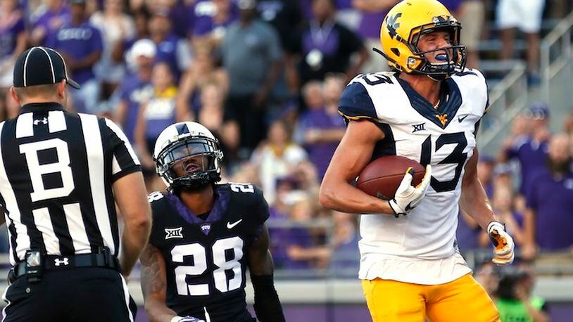West Virginia wide receiver David Sills V (13) scores on a touchdown pass as TCU cornerback Tony James (28) looks on during the second half of an NCAA college football game Saturday, Oct. 7, 2017, in Fort Worth, Texas. TCU won 31-24. (AP Photo/Ron Jenkins)