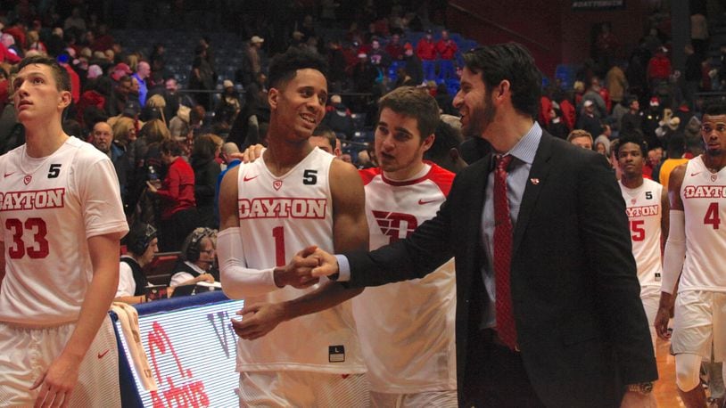 Dayton players and coaches leave the court after a victory Saturday over East Tennessee State. David Jablonski/Staff