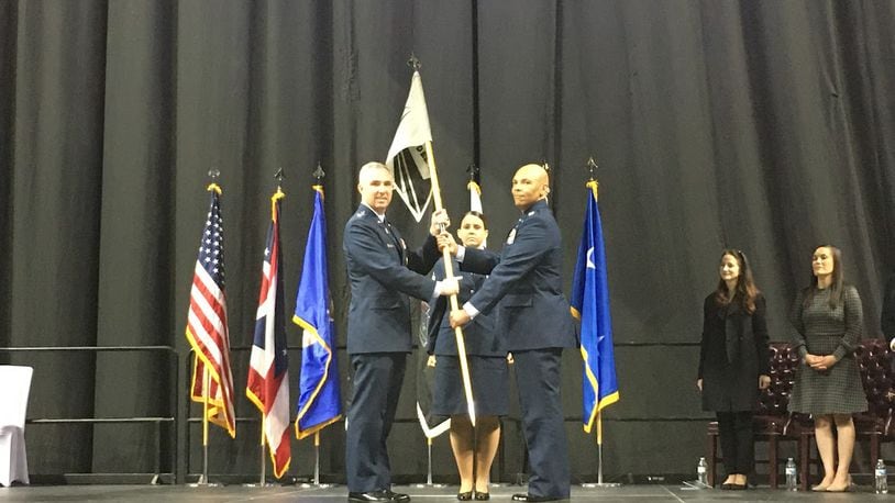 Lt. Gen. Stephen Whiting, left, commander of Space Operations Command, hands the guidon (or flag) Friday to Col. Marqus Randall, right, the first commander of the National Space Intelligence Center at the Ervin J. Nutter Center. Between the two is Chief Master Sgt. Melissa Owens, the senior enlisted leader for the new center. THOMAS GNAU/STAFF