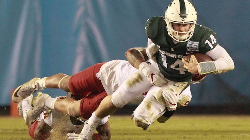 Michigan State quarterback Brian Lewerke (14) is tackled by Washington State&apos;s Frankie Luvu as Lewerke runs the ball in the second quarter of the Holiday Bowl at SDCCU Stadium in San Diego on Thursday, Dec. 28, 2017. (Hayne Palmour IV/San Diego Union-Tribune/TNS)