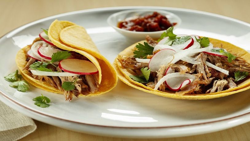 Radish, onion and cilantro top duck carnitas tacos, with the meat crisped up in a skillet after slow and low roasting. (Joan Moravek/food styling) (Chris Walker/Chicago Tribune/TNS)