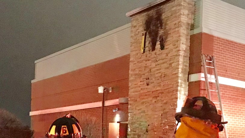 Troy fire crews look at a sign on the side of McDonald’s on W. Main St. after an electrical short caused a fire.