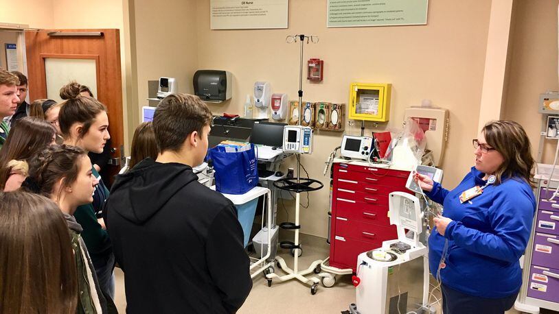 Students from Middletown and Madison high schools toured the Atrium Medical Center on Friday as part of the health provider and local chamber of commerce’s efforts to expose more youth to career options. Wendy Mitchell, nurse manager in Atrium’s emergency room, demonstrates some of the life-saving equipment used in their work.