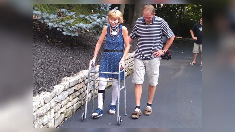 LeValley (L) walking around her neighborhood with her partner, Jim Schoenlein. She is hoping to increase her ability to walk longer distances so she can complete the final marathon in the Australia. CONTRIBUTED
