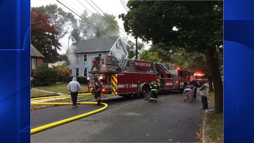 When Stoneham firefighters arrived at a two-alarm fire around 12:30 p.m. Saturday, a woman living at the single-family home was on her roof overhang escaping the flames.