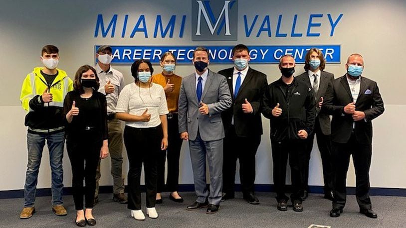 Lieutenant governor, Jon Husted, with six Miami Valley Career Technology College students  and some of their employers discuss why vocational schools are important.