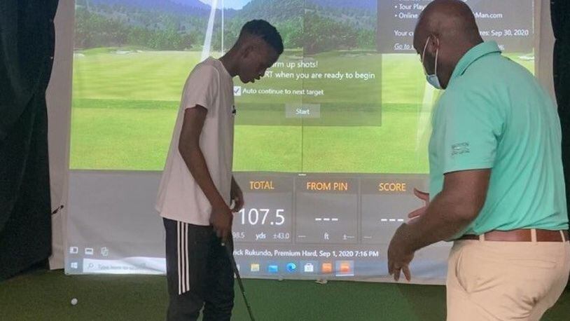 Wilberforce golf coach William Ware with budding Patrick Rukundo, a freshman out of Dayton Dunbar, at a golf simulator. CONTRIBUTED