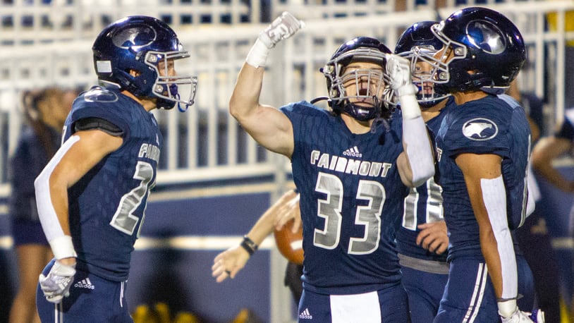 Fairmont's Stevie Doty (left), Max Conlon (33) and Kamron Payne celebrate Doty's fourth-quarter interception in Friday night's 10-7 victory over Springfield at Roush Stadium. Jeff Gilbert/CONTRIBUTED