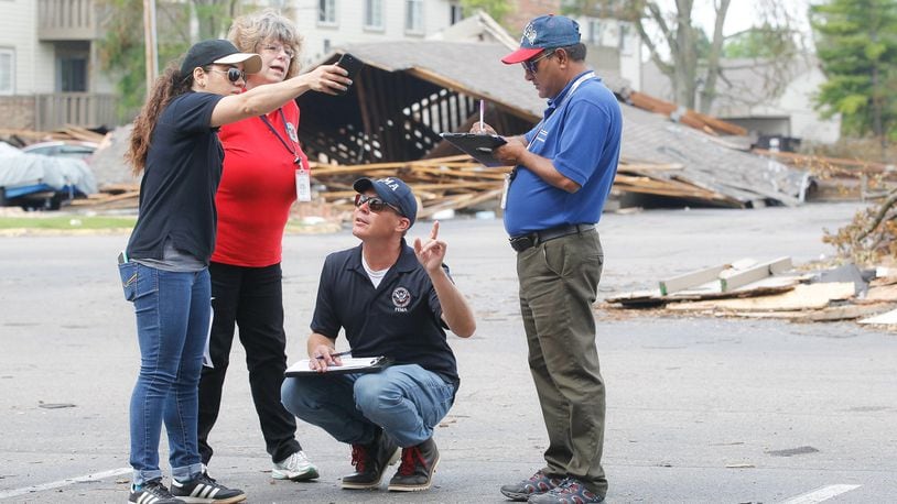 From left, Malyssa Suarez, with the Federal Emergency Management Agency (FEMA), Brigitte Bouska, with the Ohio Emergency Management Agency, Steve Cooper, of FEMA, and Ahmed Hossain, of the Small Business Administration, conduct a joint preliminary assessment of tornado damage Wednesday, June 5, at the Woodland Hills Apartments in Trotwood. CHRIS STEWART / STAFF