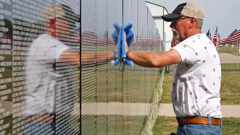 Craig Bennett, Commander of VFW Post #5451, wipes off the panels that make up The Moving Wall, a half size replica of the Vietnam Veterans Memorial in Washington, D.C. Thursday, Sept. 21, 2023 in Urbana. The Moving Wall, located in front of the Mid America Flight Museum at Grimes Field, arrived Thursday morning and will be open to the public 24 hours a day until Monday, Sept. 25. A public ceremony will be held at 10 a.m. on Saturday at the wall location. The Moving Wall's visit to Urbana is Sponsored by the Grimes Foundation and the Urbana VFW 5451. The Wall is one of two replicas of the Vietnam Veterans Memorial that travels around the country. BILL LACKEY/STAFF