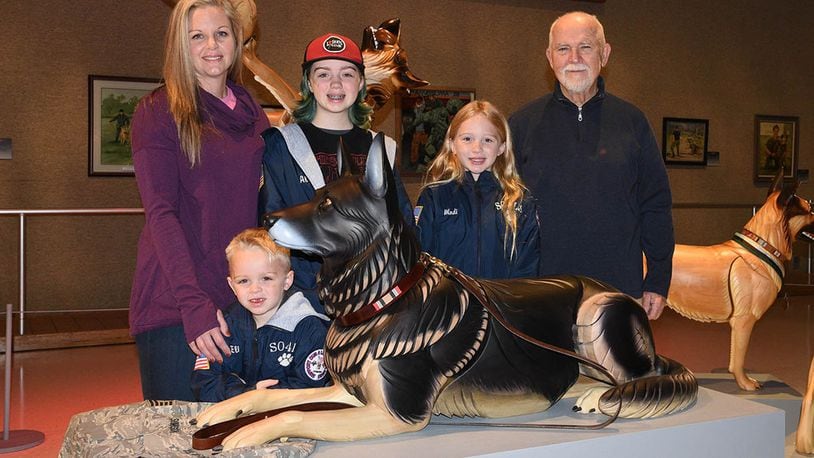 U.S. Air Force veteran Erin Simpson and her children stand with artist James Mellick at the Canine Warriors Exhibit at the National Museum of the U.S. Air Force Nov. 29. Mellick sculpted military working dog Robson L096 to represent the problem of veteran suicides. Retired Tech. Sgt. David Simpson, former military working dog handler of Robson, took his own life in 2017 having Lyme disease and post-traumatic stress disorder. (U.S. Air Force photo/Ken LaRock)