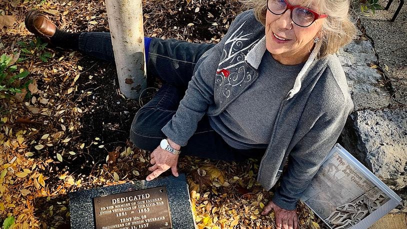 Volunteer Elaine Herrick sits by one of the markers dedicated to veterans along N. Patterson Blvd. that she help to find, clean, repair and refurbish. MARSHALL GORBY\STAFF