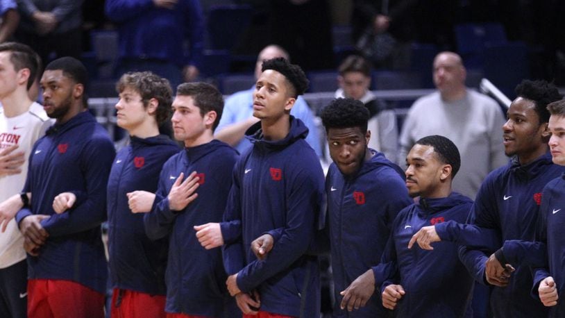 Dayton players stand for the national anthem before a game against Rhode Island on Friday, Feb. 23, 2018, at the Ryan Center in Kingston, R.I. David Jablonski/Staff