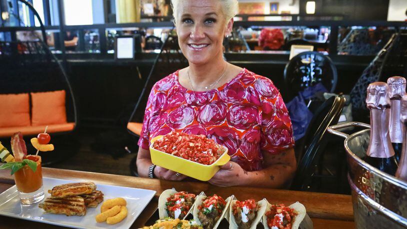 Food Network star Anne Burrell shows off some of her creations for an all-Cheetos menu for a three-day pop-up restaurant, during a press preview, Tuesday Aug. 15, 2017, in New York. Menu includes, Cheetos meatballs, Cheetos crusted fried pickles, Cheetos tacos, Mac n' Cheetos and Cheetos cheesecake. (AP Photo/Bebeto Matthews)
