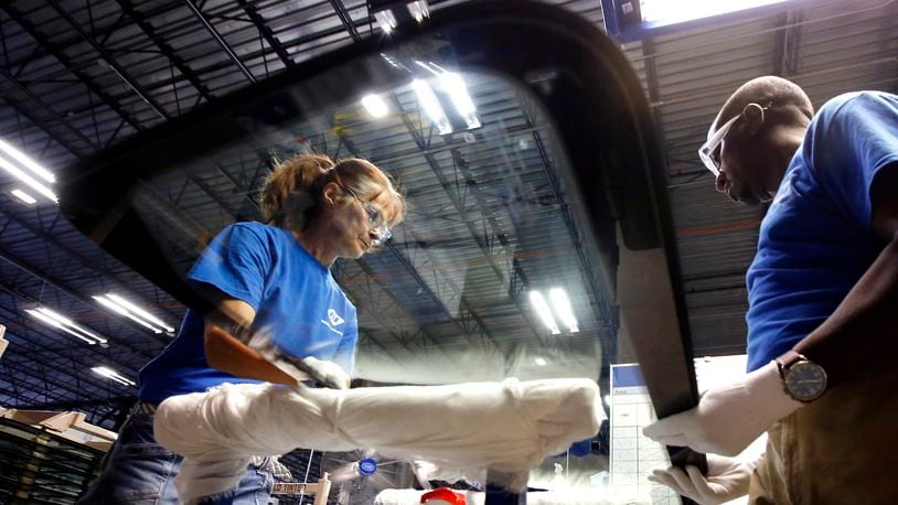 Workers at Fuyao Glass America finish an automobile windshield in the Moraine plant. Fuyao currently employs 2,300 workers and expects to need 700 more within three years. TY GREENLEES / STAFF