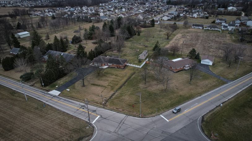 This is an aerial photo looking southeast at the intersection of Bellefontaine and Fishburg roads at the border of Dayton and Huber Heights. New housing is proposed for agricultural land near the left edge of the photo. JIM NOELKER/STAFF