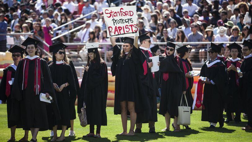 Graduating student Andrea Lorei, who helped organize campus demonstrations, holds a sign in protest during the ‘Wacky Walk’ before the 125th Stanford University commencement ceremony on June 12. The university held its commencement ceremony amid an on-campus rape case and its controversial sentencing. (Photo by Ramin Talaie/Getty Images)
