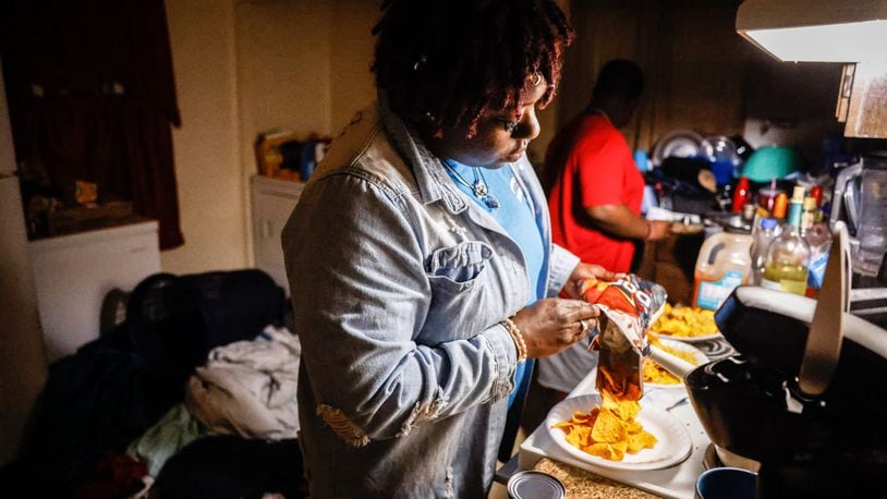 Ira Butler makes dinner for her four children in her Harrison Twp. home. Butler lost her fiance in August to COVID-19 and is now raising their children alone. JIM NOELKER/STAFF