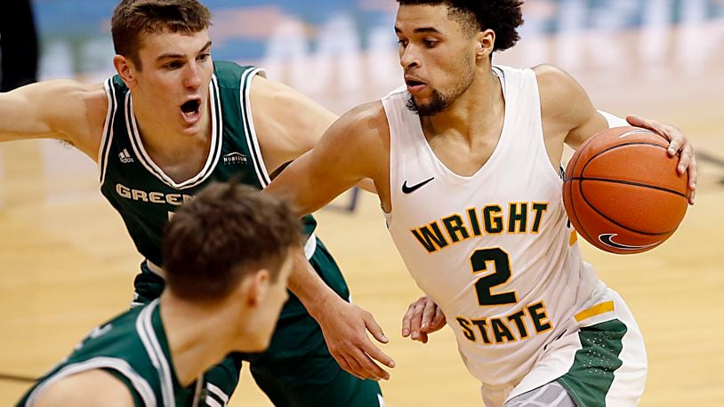 Wright State guard Tanner Holden drives to the paint on Green Bay forward Ryan Claflin and guard Lucas Stieber during a men's basketball game at the Nutter Center in Fairborn Saturday, Dec. 26, 2020. E.L. Hubbard/CONTRIBUTED