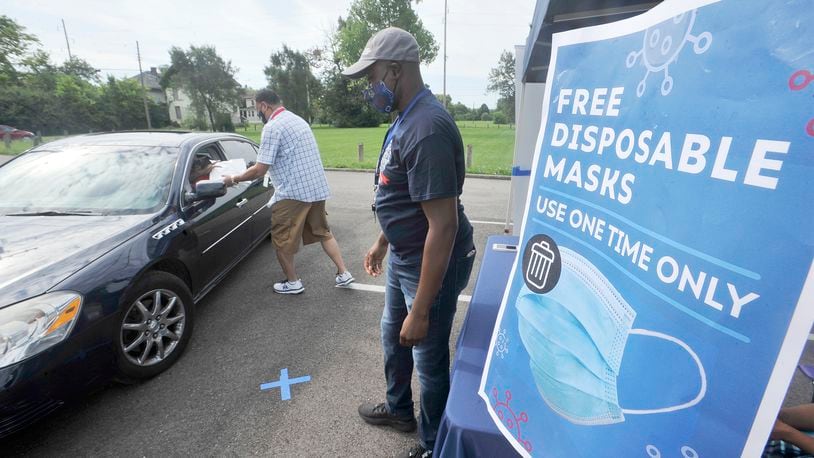 John Payne, left and Gilbert Ghand, with Dayton & Montgomery Public Health, help to giveaway free disposable mask Monday, Aug. 17, 2020, at the Mount Olive Baptist Church. MARSHALL GORBY\STAF