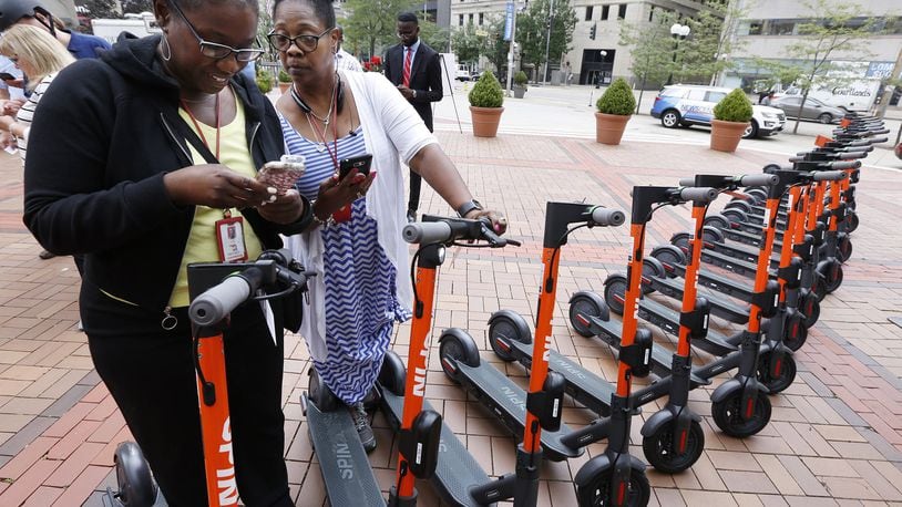 Lettia Younger, left, and Sheila Back log into the Spin Electric Scooters app at Courthouse Square before taking a test ride on the electric scooters. TY GREENLEES / STAFF