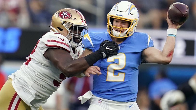 Los Angeles Chargers quarterback Easton Stick, right, is pressured by San Francisco 49ers defensive end Zach Kerr during the first half of a preseason NFL football game Sunday, Aug. 22, 2021, in Inglewood, Calif. (AP Photo/Ashley Landis)