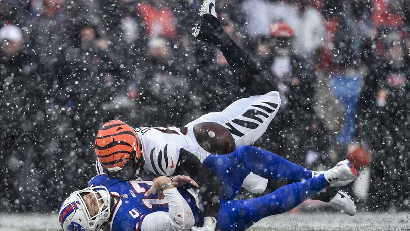 Buffalo Bills quarterback Josh Allen (17) takes a hit from Cincinnati Bengals defensive end Joseph Ossai (58) during the second quarter of an NFL division round football game, Sunday, Jan. 22, 2023, in Orchard Park, N.Y. The play was ruled an incomplete pass. (AP Photo/Adrian Kraus)