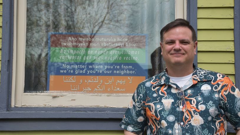 Bill Kennedy, who lives in Dayton’s South Park neighborhood, has a sign in the front window of his home that says in multiple languages, “No matter where you’re from, we’re glad you’re our neighbor.” Kennedy said he'd love to have immigrants live next door. CORNELIUS FROLIK / STAFF