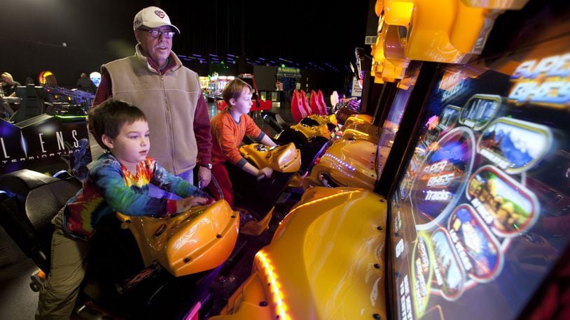 Rick Jackson from Troy supervises his grandsons as they ride the video motorcycle games at Scene 75. TY GREENLEES/STAFF