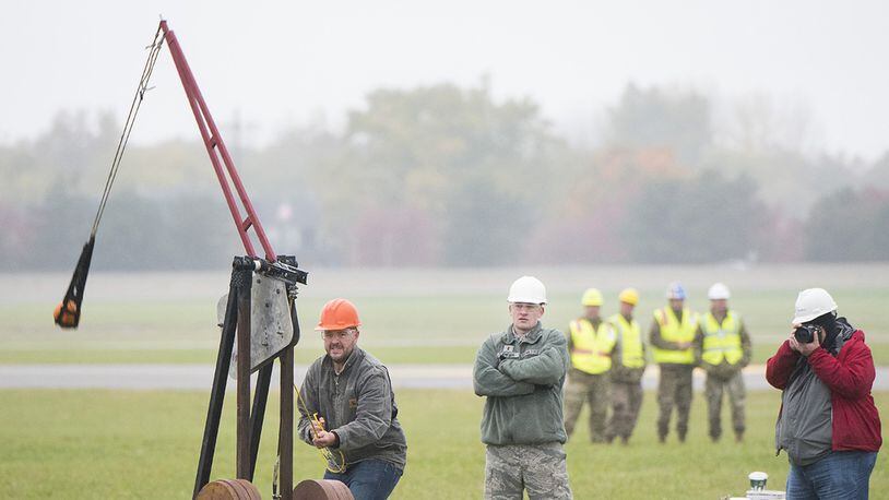 An Air Force Life Cycle Management Center’s F-15 Engineering Branch team member pulls the trigger on their trebuchet-style catapult to hurl a small pumpkin during the 14th annual Wright-Patterson Air Force Base pumpkin chuck Nov. 2. Representatives from the 88th Air Base Wing safety office watch in the background. (U.S. Air Force photo/R.J. Oriez)