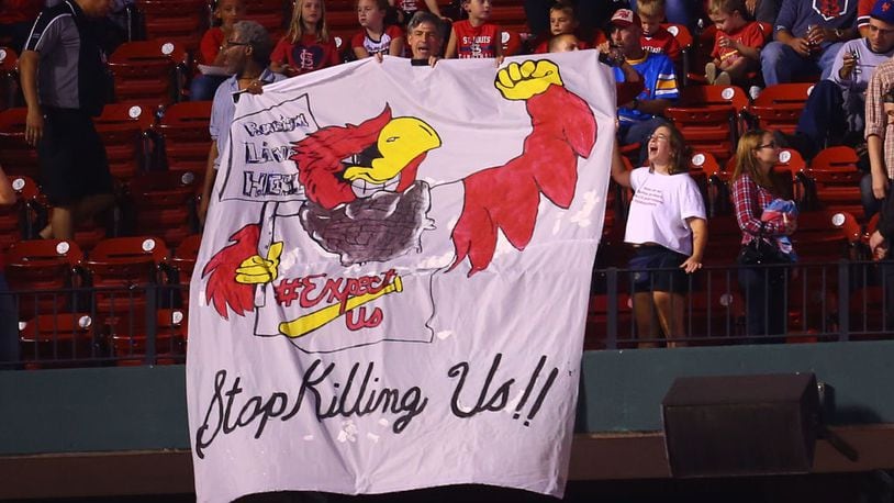 Protesters unfurl a banner during a game between the St. Louis Cardinals and the Milwaukee Brewers at Busch Stadium on Friday night .