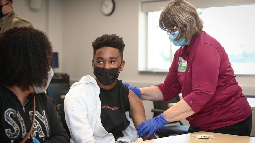 Roosevelt Jackson, 14, gets his dose of the COVID-19 vaccine on Saturday, May 15 at Dayton Children's Hospital, while his mom, Kellye Jackson, looks on. Courtesy of Dayton Children's Hospital.