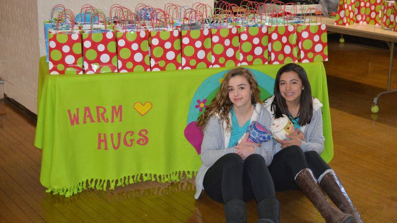 Eighth-grade Oakwood schools students Dasha Penas-Johnson (left) and Cecille Figueroa Narvaez created Warm Hugs to provide free blankets to Hispanic children who are adjusting to life in a new country. CONTRIBUTED