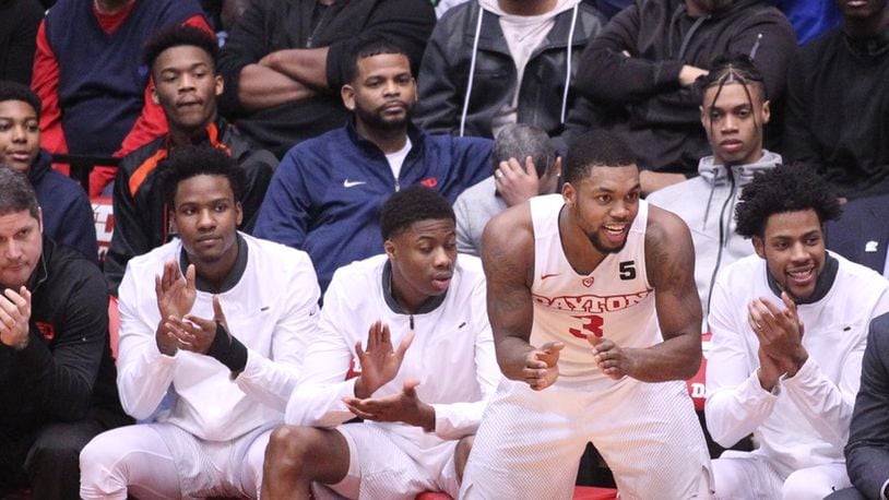 Jhery Matos, second from right in back, watches from behind the Dayton bench as Trey Landers, center, cheers during a game against Fordham on Saturday, Feb. 17, 2018, at UD Arena.