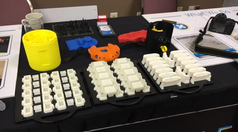 The exhibit table for Fairborn 3-D printing firm Tangible Solutions at the Additive Manufacturing Industry Summit Wednesday. THOMAS GNAU/STAFF