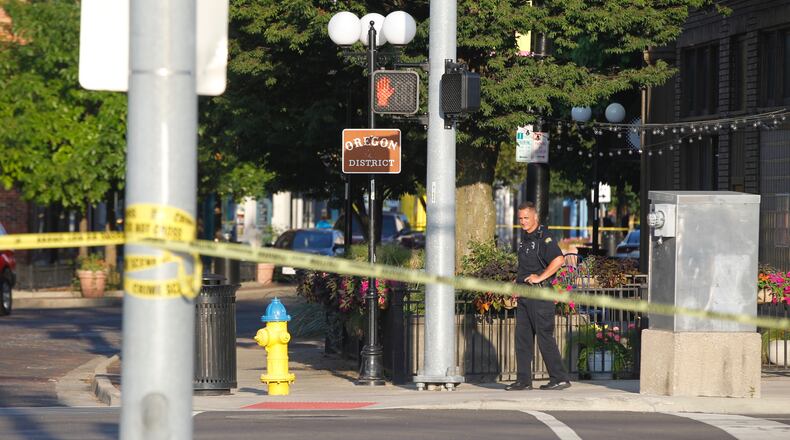 A Dayton police officer patrols the area near Fifth Street and Wayne Avenue on Sunday morning, Aug. 4. A mass shooting around 1 a.m. Sunday on Fifth Street left 10 people, including the shooter, dead. TY GREENLEES/STAFF