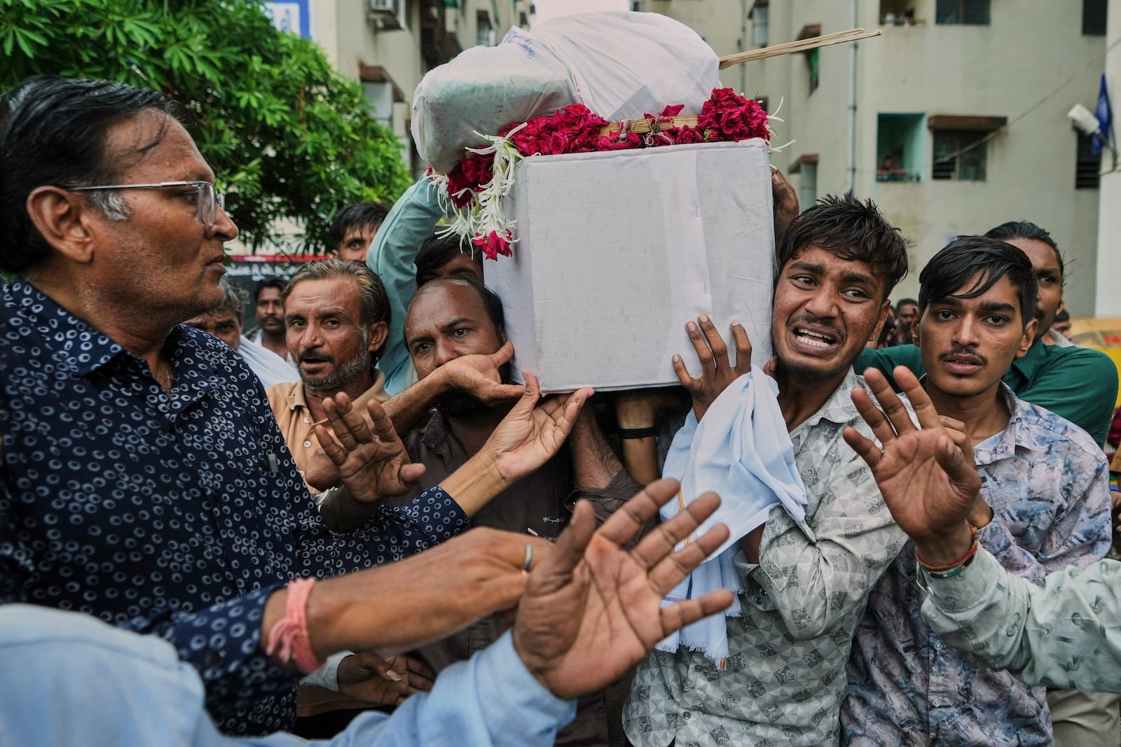 Brother, second right, family members and relatives carry coffin of Akash Patni, victim of the Air India plane crash, grieve during his funeral procession in Ahmedabad, India, Tuesday, June 17, 2025. (AP Photo/Ajit Solanki)