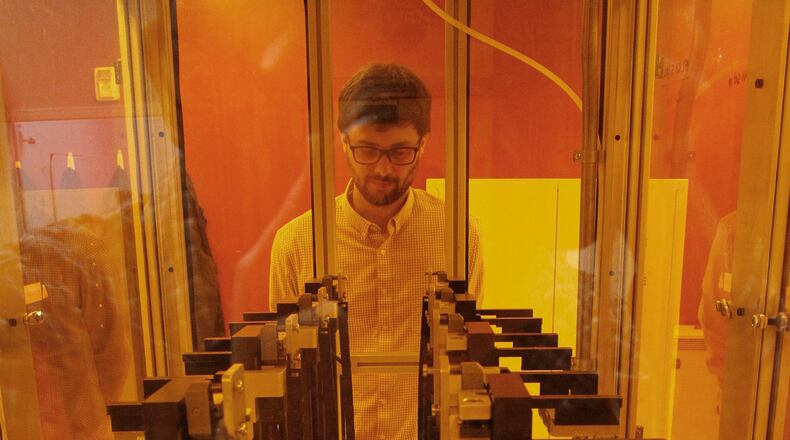 Tim Osborn, Group Leader for Additive Manufacturing Technology Development at the University of Dayton Research Institute, with a row of additive manufacturing machines, or 3-D printers, in the Additive Manufacturing Technology Development lab. TY GREENLEES / STAFF