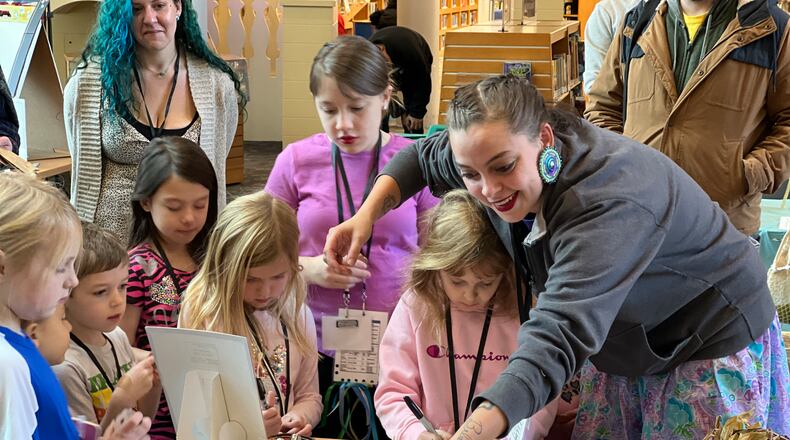 Lydia Green-Miller facilitates an activity at the Medicine Table during Saturday's REACH Fest held at the downtown Dayton Metro Library. AIMEE HANCOCK/STAFF