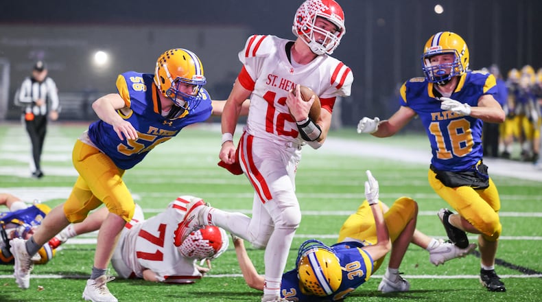 St. Henry senior quarterback Charlie Werling runs as Marion Local's Jacob Muhlenkamp tries to tackle during a touchdown run late in the second quarter of a Division VII, Region 28 championship on Friday, Nov. 21 at Mercy Health/Wapak VFW Field in Wapakoneta. BRYANT BILLING/STAFF